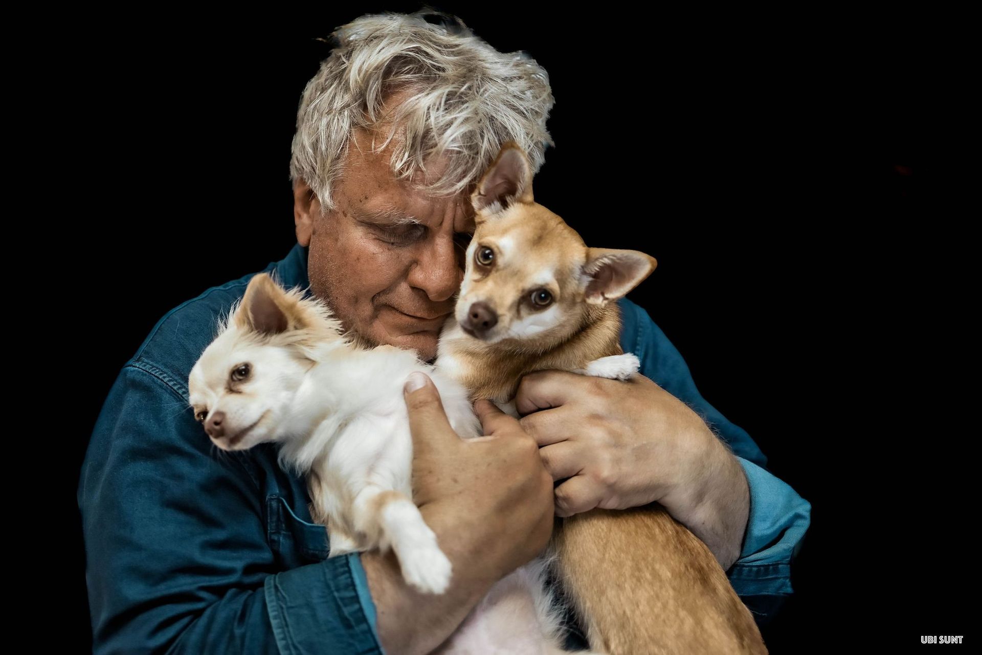 ο συγγραφέας Βρασίδας Καραλής κρατώντας αγκαλιά δύο σκυλιά